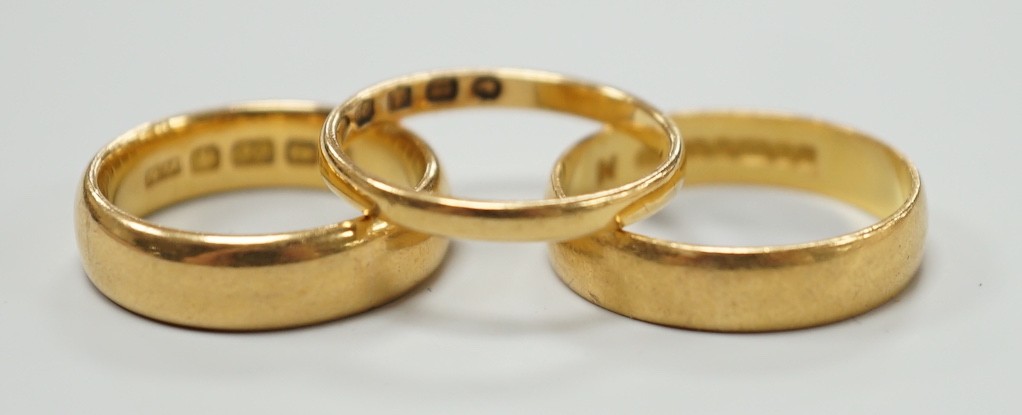 A thin Victorian 22ct gold wedding band, London, 1875, size K/L and two later 22ct gold wedding bands, including Edwardian (1901), size I, and Elizabeth II (1969), size N, 11.1 grams.